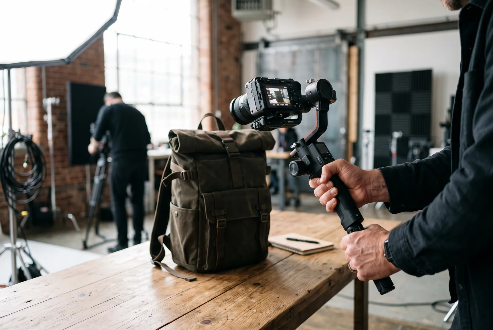 Videograf filmt einen Rucksack auf einem Tisch mit einem Kamera-Gimbal